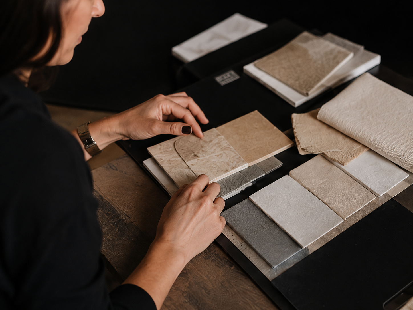 A designer reviewing fabric and stone samples at a table